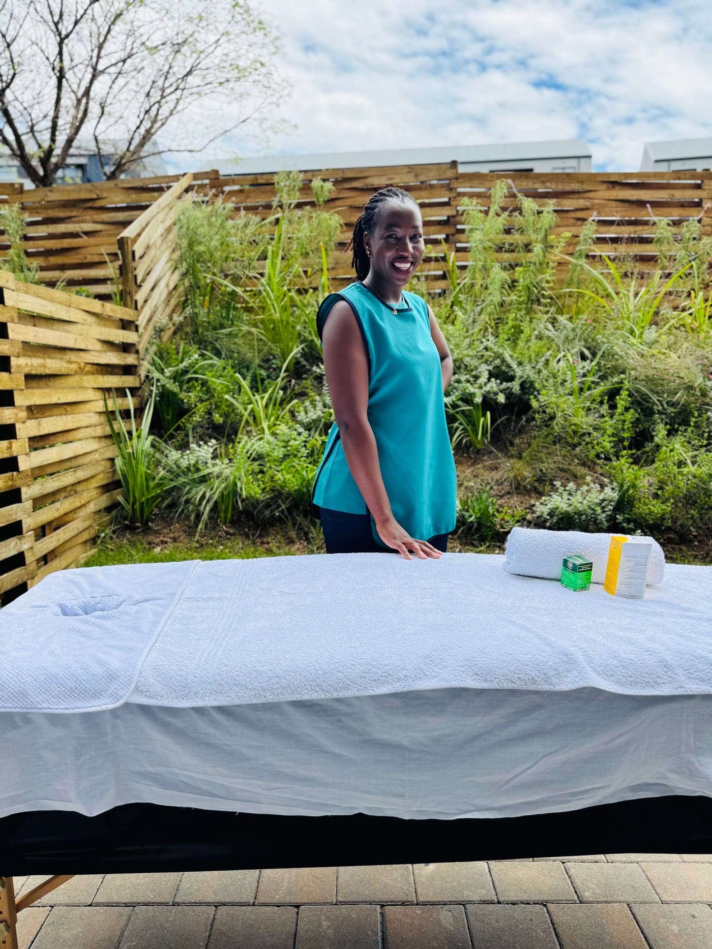 Mia Wellness Spa therapist standing beside a treatment table outdoors before a house-call massage appointment.